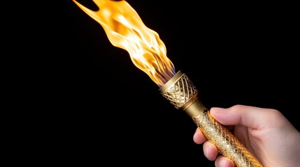 Torch with gold handle held by hand on black background
