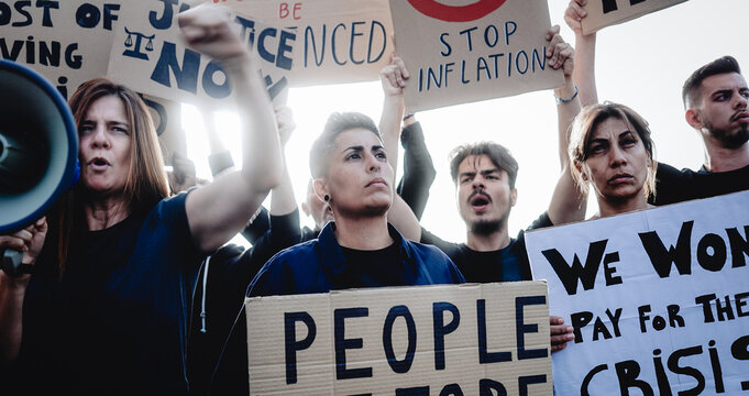 People protest financial crisis on the streets. Crowd marching for global inflation economy