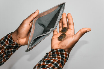 Black hands Holding empty opened men wallet With few Ghanaian cedi coins in palm. no money poor broke person concept