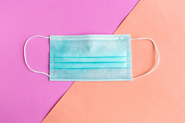 Medical mask on color geometric background. Coronavirus concept