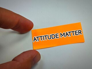 hand holding a business card with a word attitude matter
