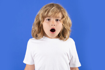 Excited kid boy on studio isolated background. Surprised face, amazed emotions of child. Shock, omg...