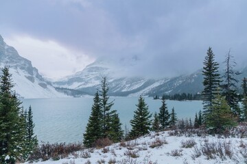 Snowy mountain lake scene. Misty, winter landscape with a serene lake nestled amongst snow-capped peaks. Nature's beauty. , Banff National Park, Alberta, Canada