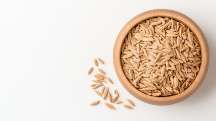 Wooden bowl filled with organic brown rice grains on white background