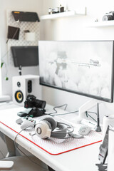 Minimalist workspace with advanced gaming equipment, high-performance computer, large monitor, headphones, microphone, and pc accessories. Gamers, streamers, or content creators in stylish interior