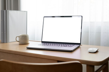 Laptop with blank white screen on wooden desk, home office, work from home.