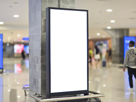 blank white billboards on pillars in the airport corridor.