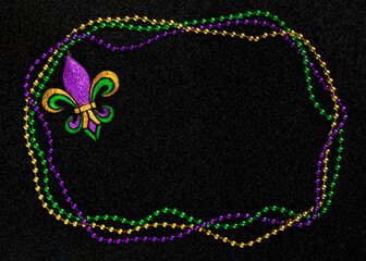 Mardi Gras beads with Fleur de lis, in glittering green, purple, and gold. Sparkling festive...