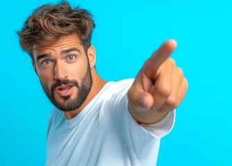 Naklejka premium Young man pointing toward the camera with a surprised expression