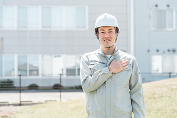 作業着姿のヘルメットを被った作業員のアジア人男性
