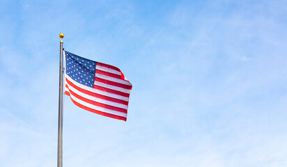 American Flag Waving Proudly On Flagpole Against Blue Sky. Flag With Stars And Stripes Symbolizing Freedom, Patriotism, National Pride. United States, Independence Day, Memorial Day Or Veterans Day