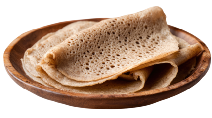 Injera Flatbread: A close-up view of thin, spongy Injera flatbread, a staple of Ethiopian cuisine, neatly stacked on a rustic wooden plate. The soft texture and delicate air pockets are visible.