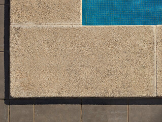 Fototapeta premium Poolside textured washed stone and concrete pavement blocks with gravel detail. Rustic light beige and cream slabs for swimming pool edging border. Serene summery atmosphere for outdoor relaxation.