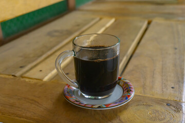 a cup of dark coffee on wooden table