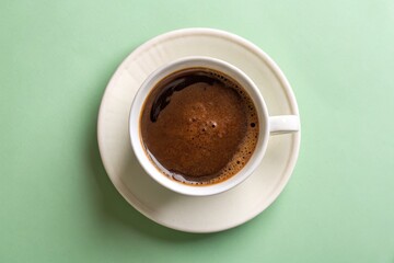 Cup of Coffee on a Green Background - Minimalist Beverage Presentation