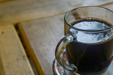 a cup of dark coffee on wooden table