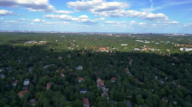 nikolassee, a residential district in berlin, featuring houses nestled within a dense forest, with the city skyline visible on the horizon. Fantastic aerial view flight speed ramp motion time lapse