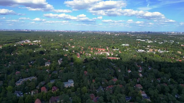 nikolassee, a residential district in berlin, featuring houses nestled within a dense forest, with the city skyline visible on the horizon. Great aerial view flight speed ramp hyper motion time lapse