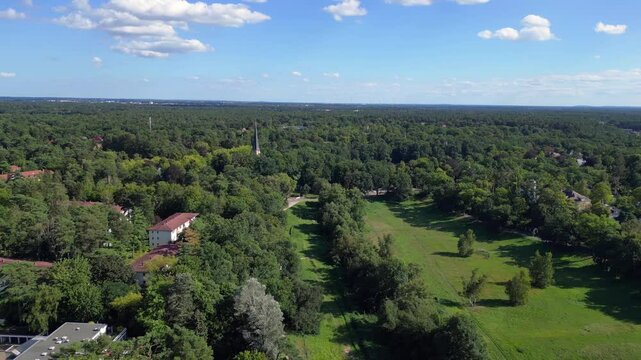 nikolassee, a residential district in berlin, featuring houses nestled within a dense forest, with the city skyline visible on the horizon. Nice aerial view flight panorama overview drone