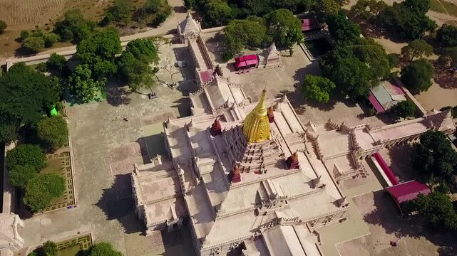 A stunning pull-out aerial reveal of the White Temple at Ananda Temple in Bagan, Myanmar, showcasing the magnificent golden Sertok and the temple's intricate architecture and spiritual significance.