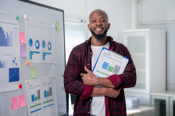 Confident african american manager holding business report, analyzing financial data near...