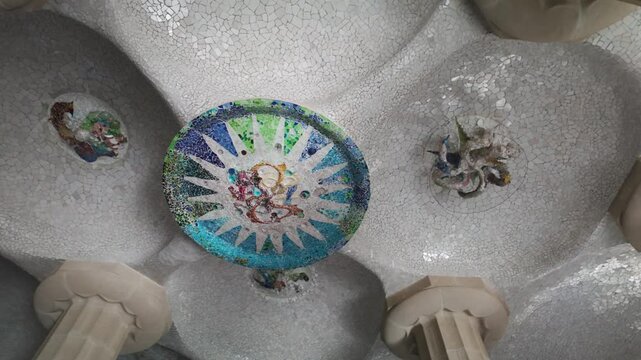 Mosaic art on the ceiling of the Hypostyle Room in Park G&uuml;ell, showcasing intricate designs and vibrant colors celebrated for their unique aesthetic and historical significance.