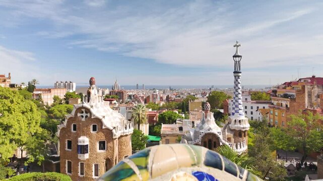 Iconic Park G&uuml;ell architecture with vibrant ceramic mosaic tiles overlooking Barcelona on a sunny day. Pull Back Shot