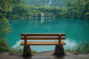 Obraz premium Bench near tranquil lake surrounded by lush greenery and cascading waterfalls during daytime