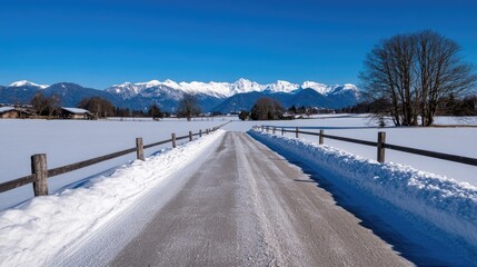Fototapeta premium Serene Winter Landscape: Snowy Road Leading to Majestic Mountains