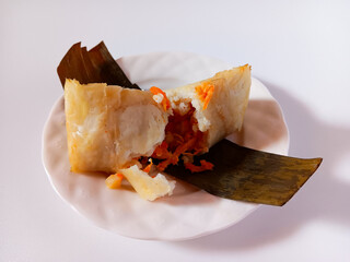 Arem-arem is an Indonesian Javanese compressed rice cake wrapped inside a banana leaf filled with...