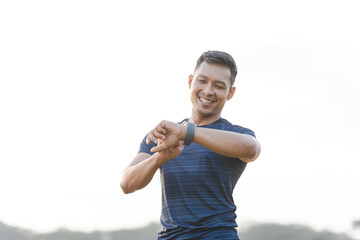 Fototapeta premium A male athlete enjoys a morning run in the park, smiling and exercising outdoors. Embracing fitness and happiness, he maintains a healthy lifestyle, feeling energized and positive in nature.