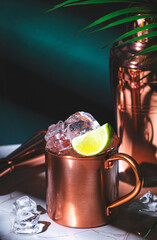 London mule alcoholic cocktail drink with gin, lime juice and ice. Green background, hard light and...