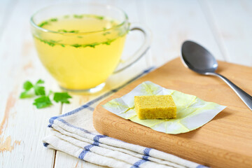 Chicken stock concentrate cube with ready to eat bouillon in a bowl on a kitchen table .