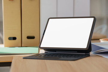 Fototapeta premium Digital tablet with white blank screen on table workspace concept.