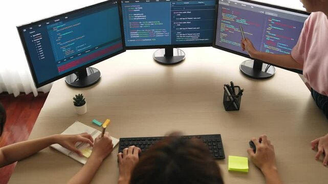 Slow motion back end software developer engineer for computer programming working together on debugging writing computing code, solving complex algorithms display on monitor in office. Burgeoning