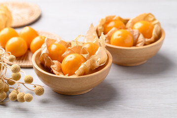 Cape gooseberry or Golden berry (Physalis peruviana) in wooden bowl on white background, Healthy fruit