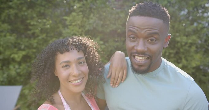 Making funny faces, african american couple enjoying time together outdoors by pool
