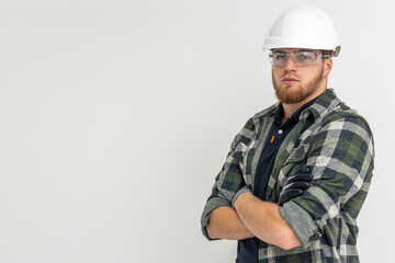 Portrait of a male builder. Engineer in overalls and helmet on a light background.