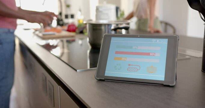 Using tablet for monitoring energy usage while cooking in modern kitchen