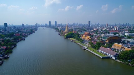Obraz premium Aerial view of Bangkok's vibrant cityscape along the Chao Phraya River, featuring cultural landmarks such as Wat Arun and the Grand Palace, with modern skyscrapers in the background