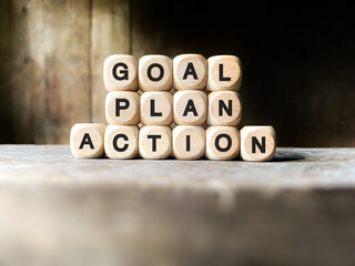 Inspirational and Motivational Success Quote - GOAL PLAN ACTION on wooden cubes background. Stock photo.