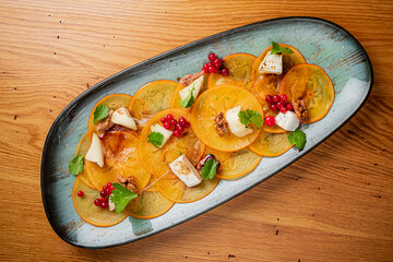 persimmon carpaccio with cheese and berries