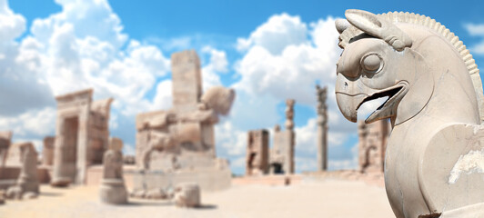 Horizontal banner with stone statue of mythical creature griffin and columns of Apadana Palace at...