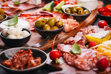 Assorted appetizers and antipasti platters on wooden tray, catering concept