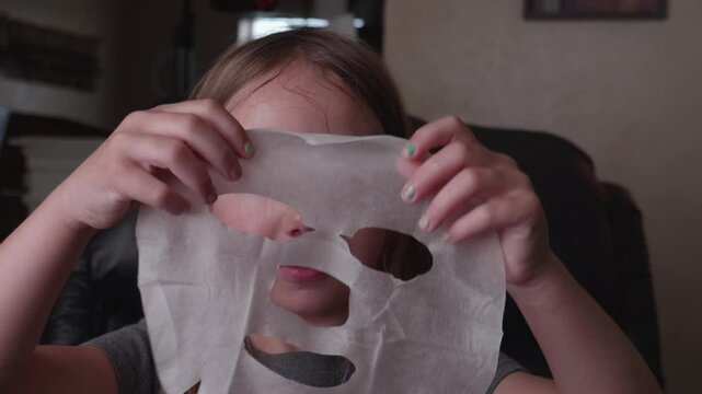 Little Girl Putting on Facial Mask Sheet