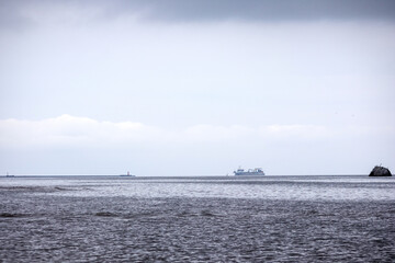 
a bay with calm water and a ship visible in the distance.