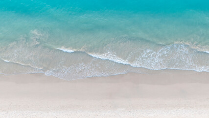 Tropical Beach with the soft wave water of the sea on the sandy beach background as texture with splashes and bubbles