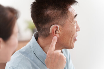 Obraz premium 補聴器をつけて会話するシニア男性