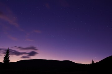Fototapeta premium Galaxy Gradient: A space scene with a gradient of deep black transitioning to shades of purple, pink, and blue, dotted with stars