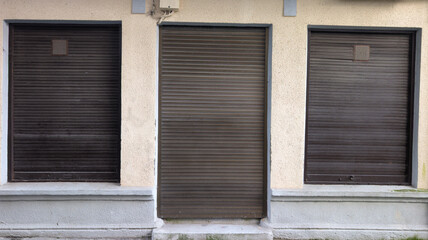 roll-up metal door windows on shop facade rusty roller shutter entrance boutique